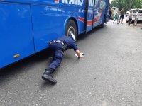 Policjant sprawdza podwozie autokaru.