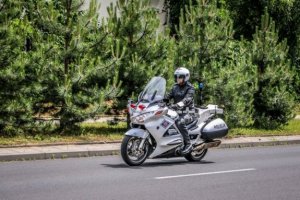 Policjant ruchu drogowego jedzie na służbowym motocyklu