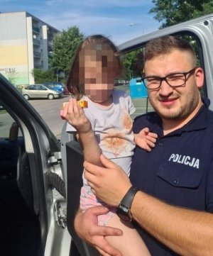 Policjant trzyma na rękach odnalezioną dziewczynkę