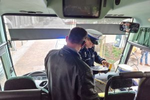 Policjantka podczas kontroli kierowcy autobusu. Zdjęcie wykonane wewnątrz pojazdu.