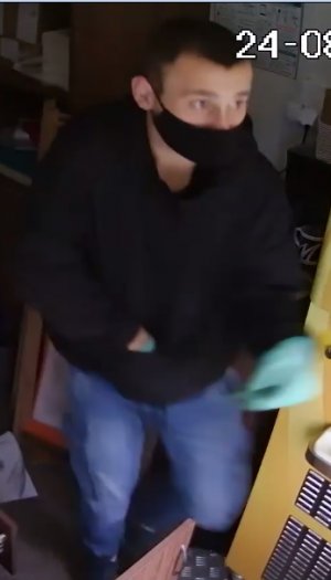 Wizerunek jednego ze sprawców kradzieży z włamaniem do lodziarni. Mężczyzna - krótkie ciemne włosy, ubrany w długie spodnie jeansy, czarną bluzę, zielone rękawiczki, na twarzy czarna maseczka
