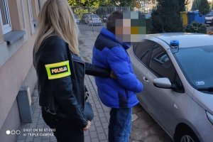 Policjantka z zatrzymanym przy nieoznakowanym radiowozie Policji.