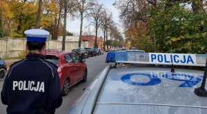 Policjantka ruchu drogowego czuwa nad bezpieczeństwem w rejonie cmentarza.