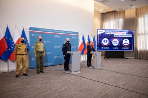 Minister z przedstawicielami służb podczas konferencji.