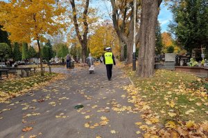 Policjant patroluje teren cmentarza.