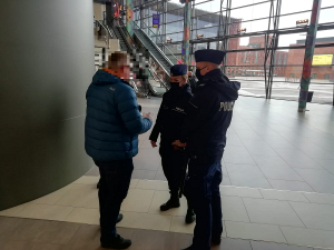 Policjanci rozmawiają z jednym z klientów sklepu.