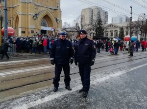 Komendant Miejski Policji w Łodzi wraz z Zastępcą Naczelnika Wydziału Ruchu Drogowego KMP w Łodzi podczas zabezpieczania uroczystości stoją przed łódzką Katedrą.