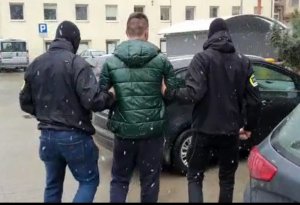 Policjanci prowadzą drugiego  z zatrzymanych sprawców rozboju.