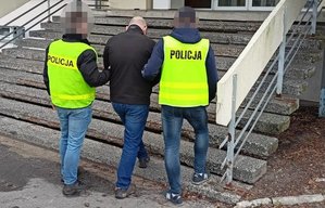 Policjanci prowadza zatrzymanego.