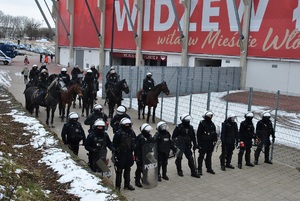 Służby podczas zabezpieczenia w tym sekcje konne stoją w dwóch rzędach obok stadionu.