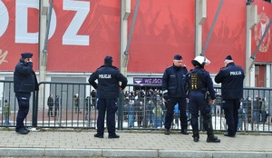 Policjanci nadzorują wejście na stadion kibiców przyjezdnych.