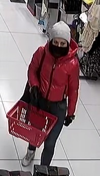 Wizerunek sprawczyni kradzieży artykułów drogeryjnych. Kobieta była ubrana w czerwoną kurtkę z kapturem, grafitowe spodnie oraz kremową czapkę. Miała założoną maseczkę na twarzy oraz przewieszoną czarną torebkę przez ramię.