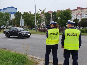 Policjanci kontrolujący prędkość pojazdów jadących jezdnią.