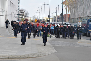 Przemarsz kibiców Widzewa Łódź pod nadzorem policjantów.