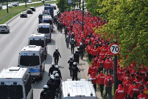 Przemarsz kibiców Widzewa Łódź pod nadzorem policjantów.