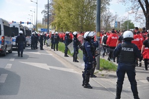 Przemarsz kibiców Widzewa Łódź pod nadzorem policjantów.