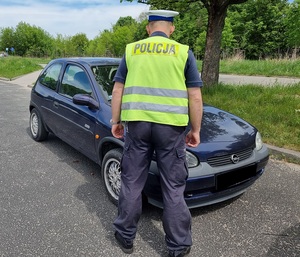 Policjant ogląda uszkodzenia pojazdu.