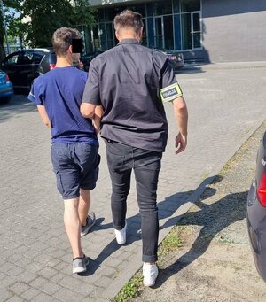 Policjant prowadzi sprawcę.