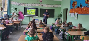 Policjant w trakcie zajęć z dziećmi w klasie szkolnej.