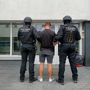 Policjanci stoją z zatrzymanym