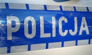 Napis Policja na drzwiach radiowozu.