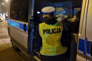 Senior siedzi w radiowozie pod opieką łódzkich policjantów.