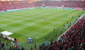 Stadion Widzewa,  na murawie piłkarze, na trybunach siedzą kibice.