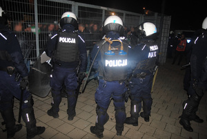 Policyjne zabezpieczenie opuszczania stadionu przez kibiców obu drużyn po zakończonym meczu.