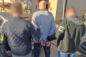 Nieumundurowani policjanci prowadzą podejrzanego.