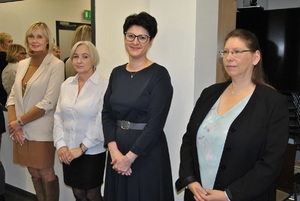 Wyróżnieni pracownicy Policji stoją w sali na tle lustra.