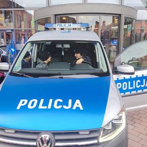 W radiowozie policyjnym obok policjantki siedzi chłopczyk.