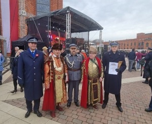 Komendant Miejski Policji w Łodzi stoi wraz z uczestnikami na placu Manufaktury.