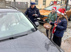 Dzieci i policjantka rozmawiają z kierującym.