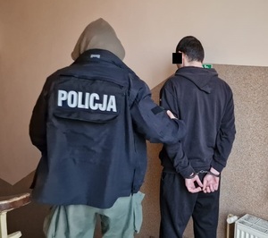 Drugi z zatrzymanych prowadzony na terenie komisariatu przez Policjanta