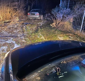 samochód stojący w zaroślach, na ścieżce widać też drugi samochód na masce leżą kluczyki.