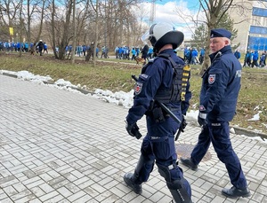 Policjanci biorący udział w zabezpieczeniu meczu , dowódcy zabezpieczenia nadzorują przemarsz kibiców.