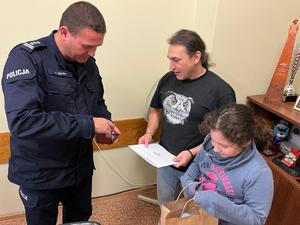 Komendant Miejski Policji w Łodzi, wyróżniony mężczyzna oraz jego córka.