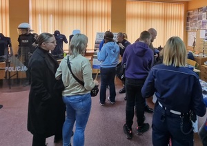 W sali wśród wystawionych eksponatów policjanci i uczestnicy dni otwartych szkoły.