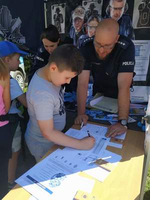 Policjant z dzieckiem na pikniku.
