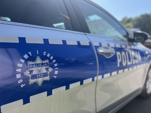 Oznaczenie boczne radiowozu na którym widnieje napis pomagamy i chronimy.