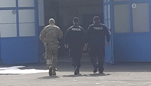 Funkcjonariusze różnych służb mundurowych dokonują sprawdzenia budynku pod kątem występowania zagrożeń.