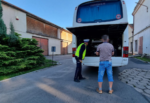 Policjant z łódzkiej drogówki kontroluje autokar.