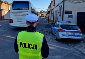 Policjant z łódzkiej drogówki kontroluje autokar.