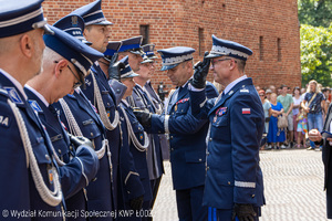 Komendant Wojewódzki Policji w Łodzi wraz z I Zastępcą Komendanta Głównego Policji przypinają odznaczenia policjantom.