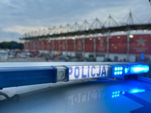Napis Policja na tle stadiony Widzewa Łódź.