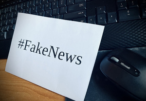 Napis fake news, poprzedzony znakiem specjalnym #, na białej kartce.