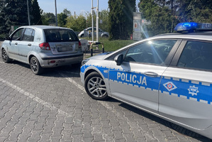 Radiowóz policyjny przy którym stoi do kontroli Hyundai.