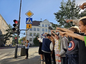 Dzieci i policjantka przy przejściu dla pieszych.