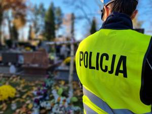 Policjantka stoi przed grobami.