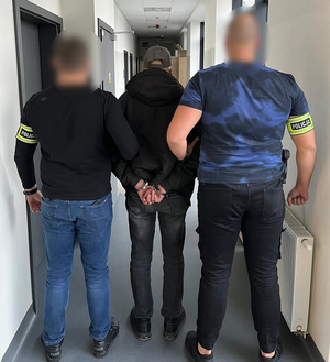 Policjanci prowadzą sprawcę.